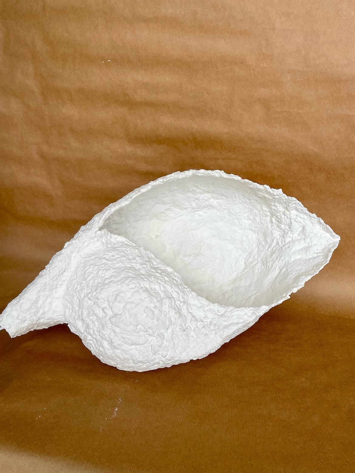 Lampe blanche en pulpe, éteinte, sur un fond ocre