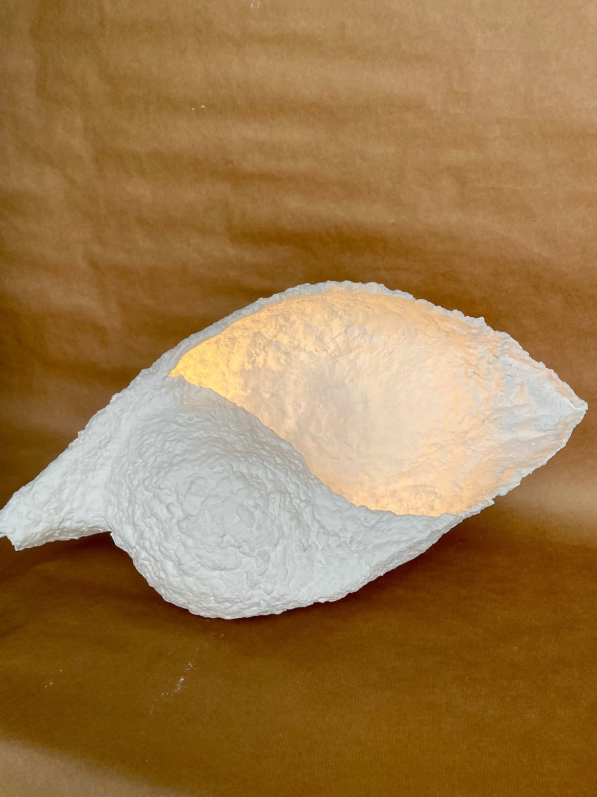 Lampe blanche en pulpe éclairée, aux bords irréguliers